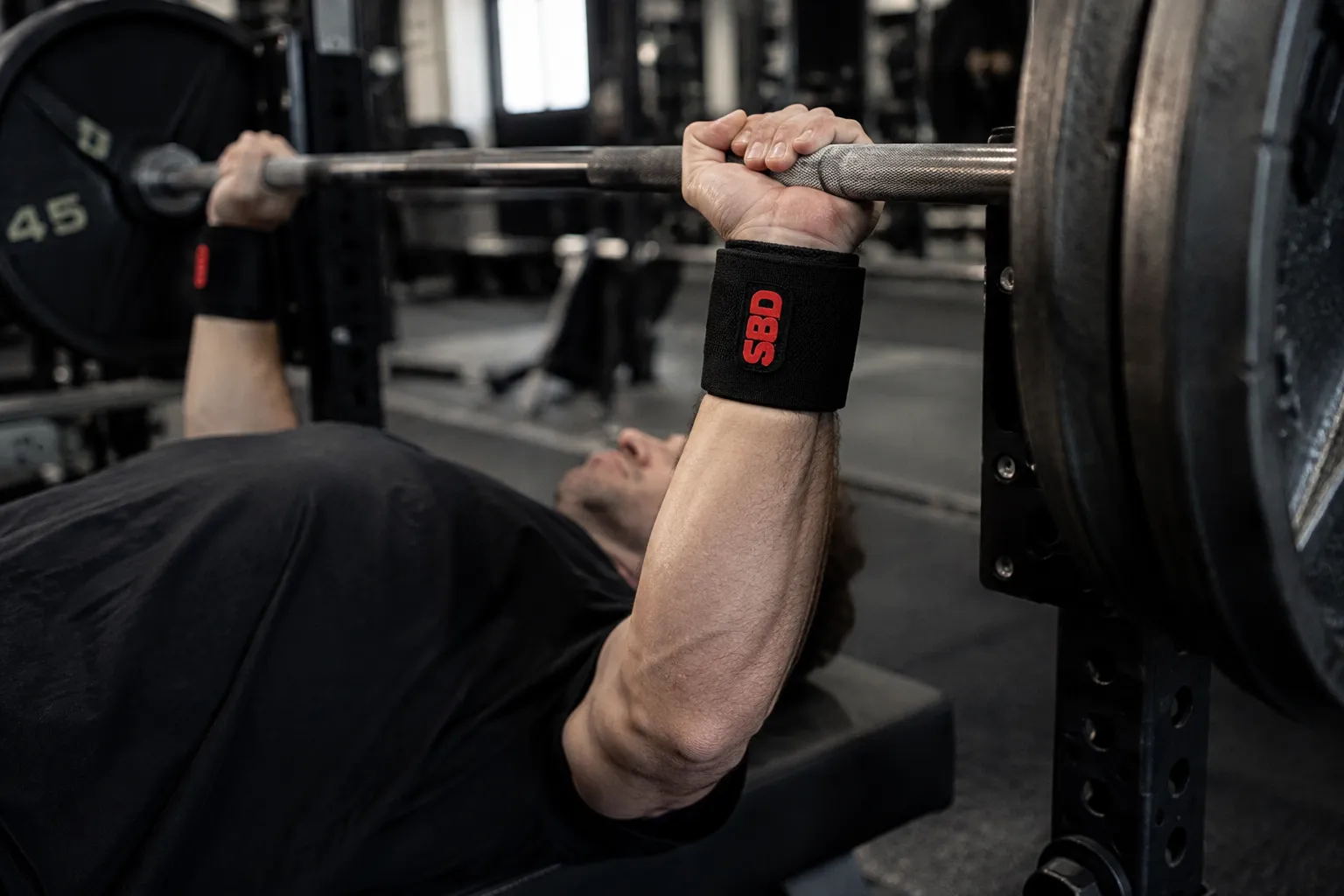 Stiff SBD wrist wraps supporting a heavy bench press grip